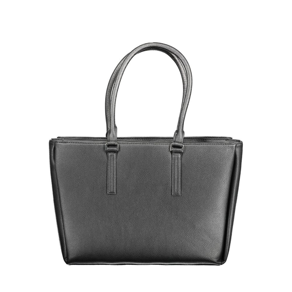 Shoulder Handbag by Calvin Klein for women in faux grained leather black features a signature silhouette, showcasing a secure snap, zipper & magnetic and signature built-in-compartments & internal-pockets with versatile shoulder-strap & handle for a sophisticated look.