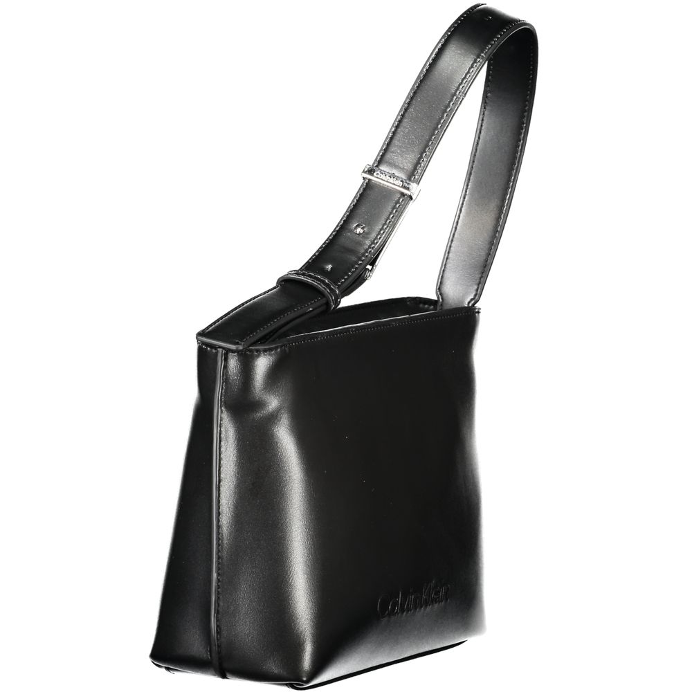This Shoulder Handbag by Calvin Klein for women in polyester polyethylene faux leather and black presents a sculptural silhouette featuring a secure zipper, ample internal-pockets, and versatile shoulder-strap & handle for a sculptural finish.