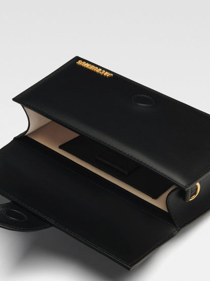 Small Crossbody Flap Handbag by Jacquemus for women in leather black & gold features an multi-faceted design with a secure flap & magnetic, ample cardholder, and versatile crossbody-strap, shoulder-strap, adjustable-strap & handle for a multi-faceted finish.