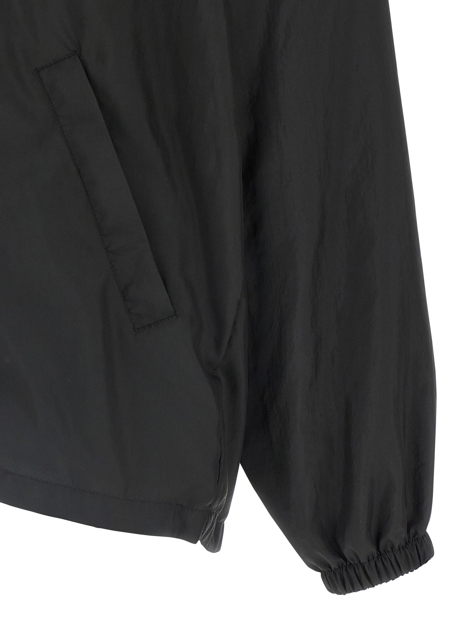 Hooded Windbreaker Jacket by Balenciaga for men in polyester black presents a resilient silhouette, artfully detailed with a sophisticated and functional hooded & windproof for a resilient finish.