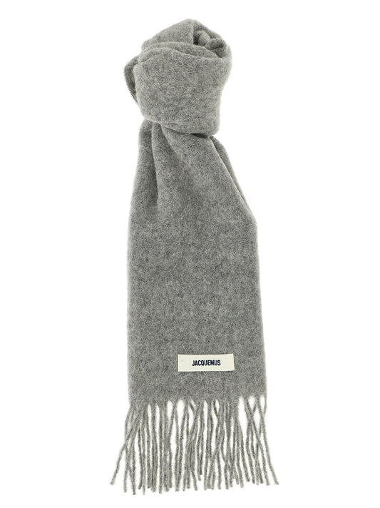 Scarf by Jacquemus for men in mohair alpaca polyamide & virgin wool gray & signature features a snug silhouette, perfectly showcasing the elegant drape and premium finish of the Mohair Alpaca Polyamide & Virgin Wool Wrap Fringes Scarf.