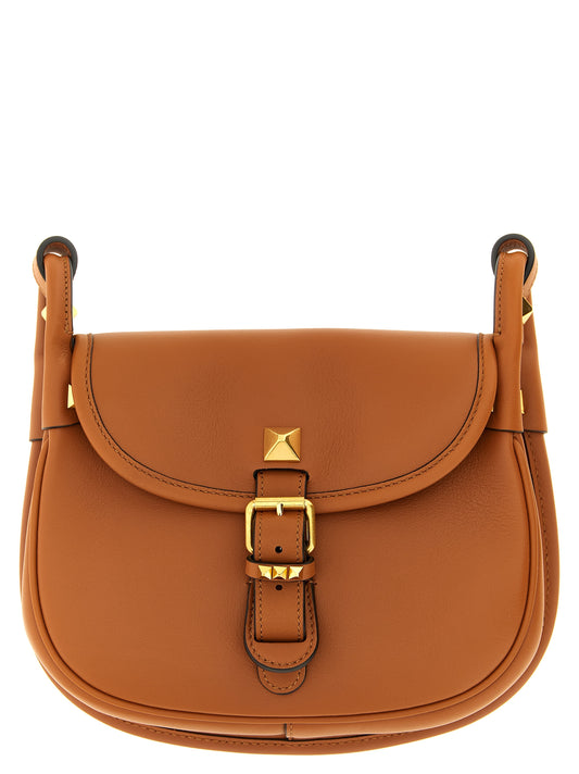 Small Shoulder Flap Bag by Valentino Garavani for women in calfskin leather brown & signature features an effortlessly chic silhouette with a secure flap & magnetic, ample , and versatile shoulder-strap & adjustable-strap for effortlessly chic everyday luxury.
