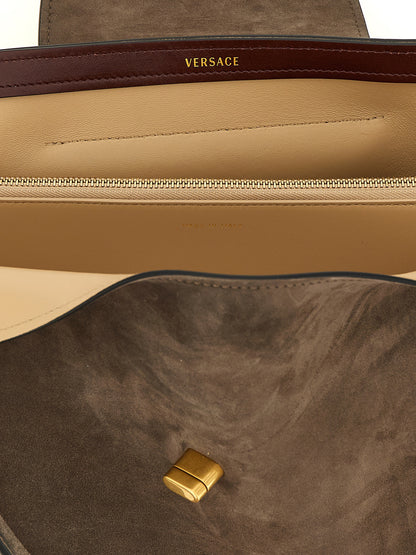 Medium Shoulder East West Flap Bag by Versace for women in calfskin & lambskin leather brown presents a versatile silhouette, showcasing a secure flap and versatile built-in-compartments with versatile shoulder-strap & handle for a sophisticated look.