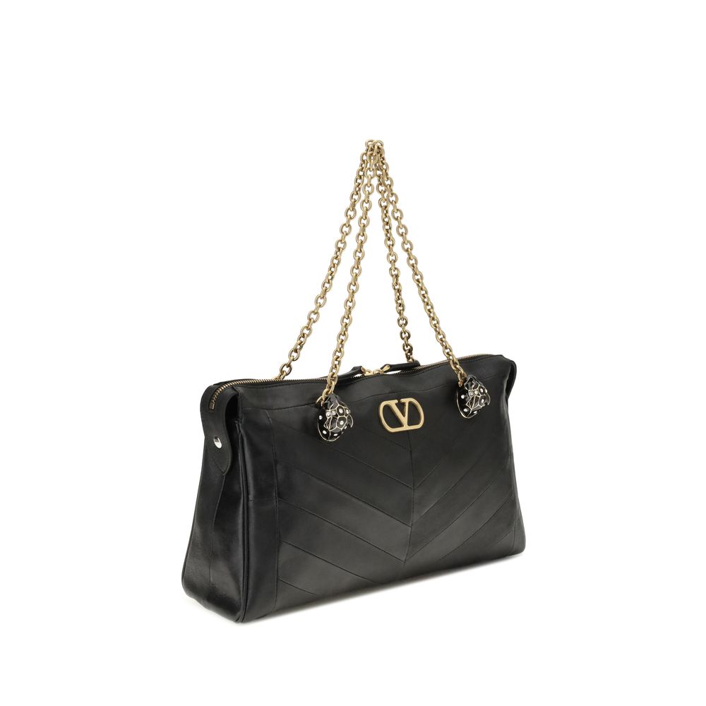 Medium Shoulder Bag by Valentino Garavani for women in leather & brass black, chevron, signature & patchwork features a statuesque silhouette, showcasing a secure zipper & button and statuesque with versatile shoulder-strap & handle for a statuesque finish.
