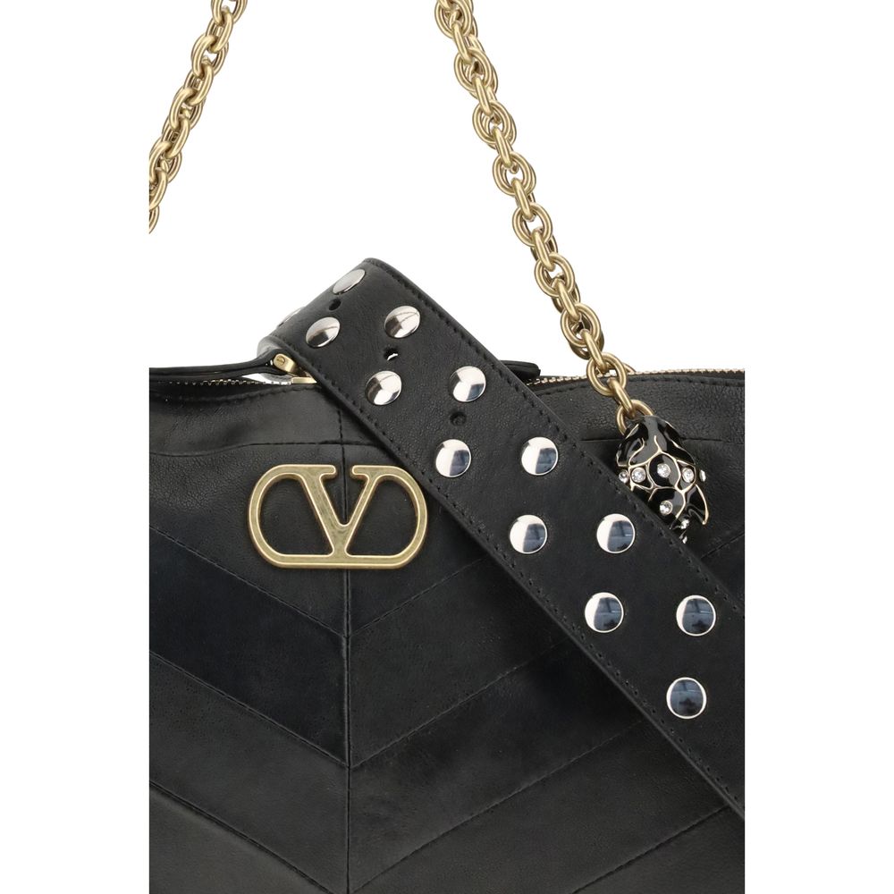 Medium Shoulder Bag by Valentino Garavani for women in leather & brass black, chevron, signature & patchwork presents a statuesque silhouette, showcasing a secure zipper & button and statuesque with versatile shoulder-strap & handle for a sophisticated look.