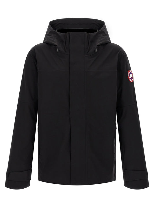 Hooded Rain Coat by Canada Goose for men in stretch polyamide black features an impenetrable silhouette, perfectly blending water-resistant, pockets, hooded & windproof with a sophisticated hooded neckline for a impenetrable finish.