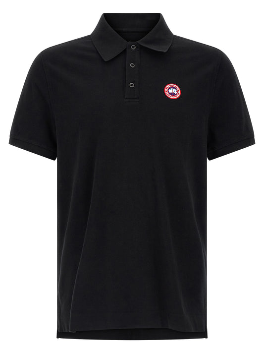 Polo Shirt by Canada Goose for women in cotton black presents a sleek silhouette, featuring a refined asymmetric neckline and short-sleeve for a sleek finish.