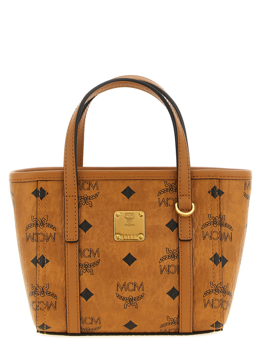 This Mini Shopper Tote Bag by MCM for women in cotton canvas poly leather brown, gold, natural & monogram features an on trend Visetos Cotton Canvas Poly Leather Mini Shopper Tote Bag design with a secure , ample , and on trend shoulder-strap & handle.