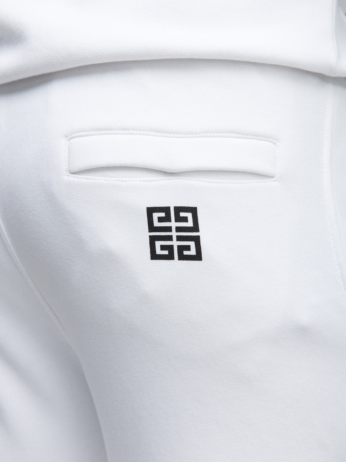 Joggers by Givenchy for men in cotton white features a polished silhouette with a polished slim, reaching a polished long and finished with a polished .