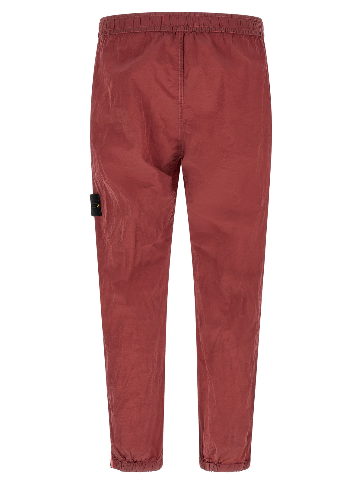 Joggers by Stone Island for men in nylon red features a polished silhouette with a polished regular-fit, reaching a polished long and finished with a polished .