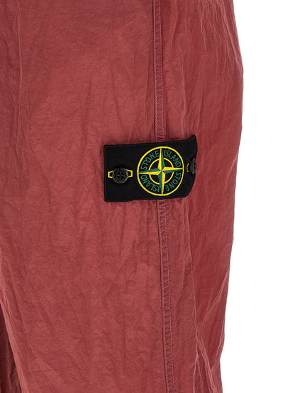 Joggers by Stone Island for men in nylon red presents a tailored silhouette, showcasing a tailored regular-fit and long cut with a refined for a truly tailored aesthetic.