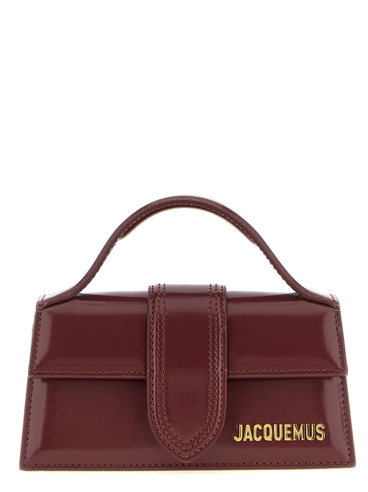 This Handbag by Jacquemus for women in patent calfskin leather and bordeaux & gold presents a sculptural silhouette featuring a secure , ample , and versatile shoulder-strap & handle for a sculptural finish.