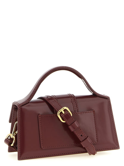 Handbag by Jacquemus for women in patent calfskin leather bordeaux & gold features a signature silhouette, showcasing a secure and signature with versatile shoulder-strap & handle for a sophisticated look.