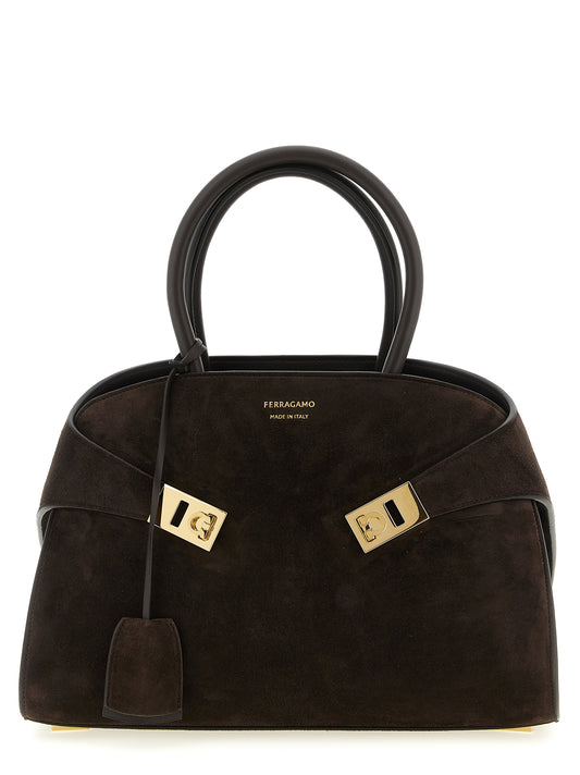 Handbag by Ferragamo for women in suede calf & goat leather brown & gold presents a ornamental silhouette, showcasing a secure zipper & buckle, ample , and versatile shoulder-strap, detachable-strap & handle for a ornamental finish.