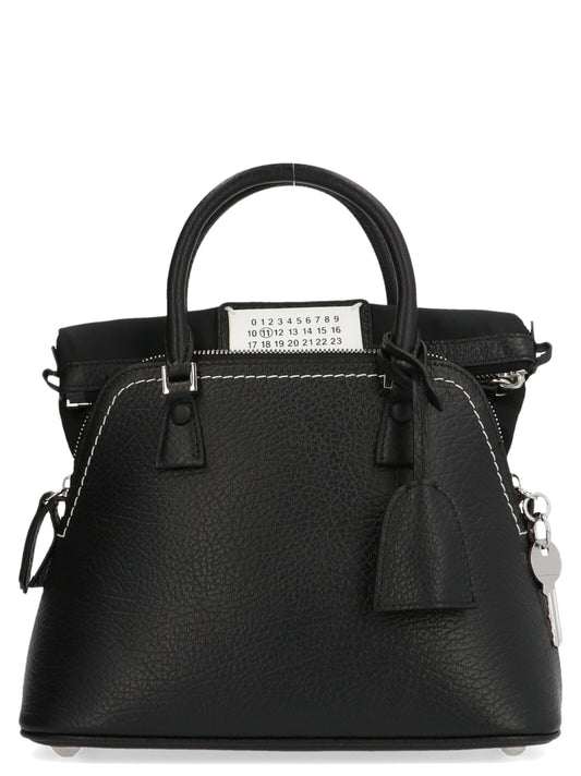 Mini Handbag by Maison Margiela for women in canvas & calfskin leather black & signature features a signature silhouette, showcasing a secure zipper and signature with versatile shoulder-strap, handle & adjustable-strap for a sophisticated look.