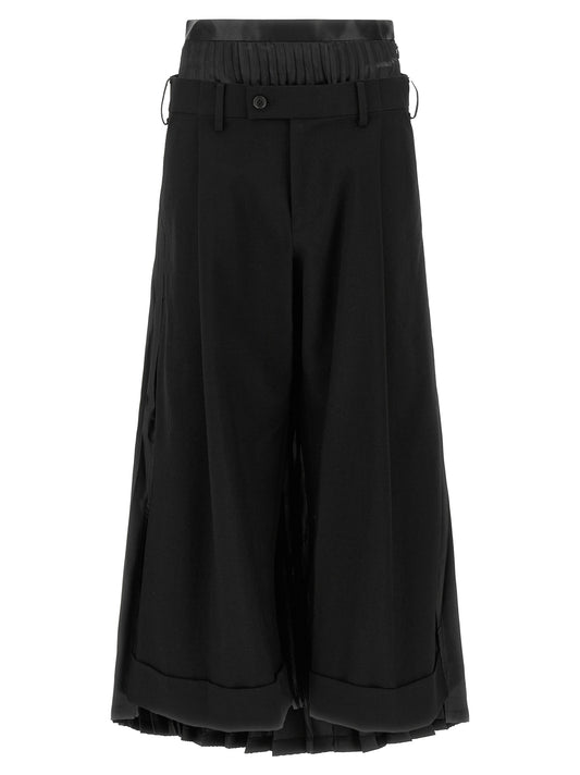 Trousers by Junya Watanabe for women in wool black presents a perennial silhouette, meticulously tailored with a wide cut, long finish, and an elegant .