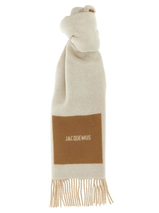 Scarf by Jacquemus for men in virgin wool beige showcases a on trend silhouette, artfully capturing the on trend essence of the Virgin Wool Foulard Wrap Fringes Scarf design with a sophisticated finish.