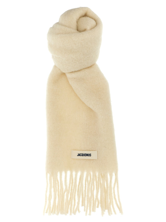 Scarf by Jacquemus for women in mohair virgin alpaca wool & polyamide white showcases a on trend silhouette, artfully capturing the on trend essence of the Mohair Virgin Alpaca Wool & Polyamide Foulard Wrap Fringes Scarf design with a sophisticated finish.