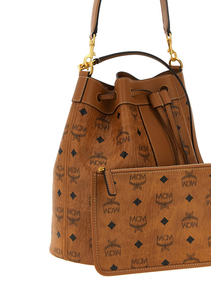 Bucket Pouch Shoulder Bag by MCM for women in canvas microfiber suede & leather brown, gold, patterned & monogram features an effortlessly chic silhouette with a secure zipper & drawstring, ample , and versatile shoulder-strap, handle, adjustable-strap & detachable-strap for effortlessly chic everyday luxury.