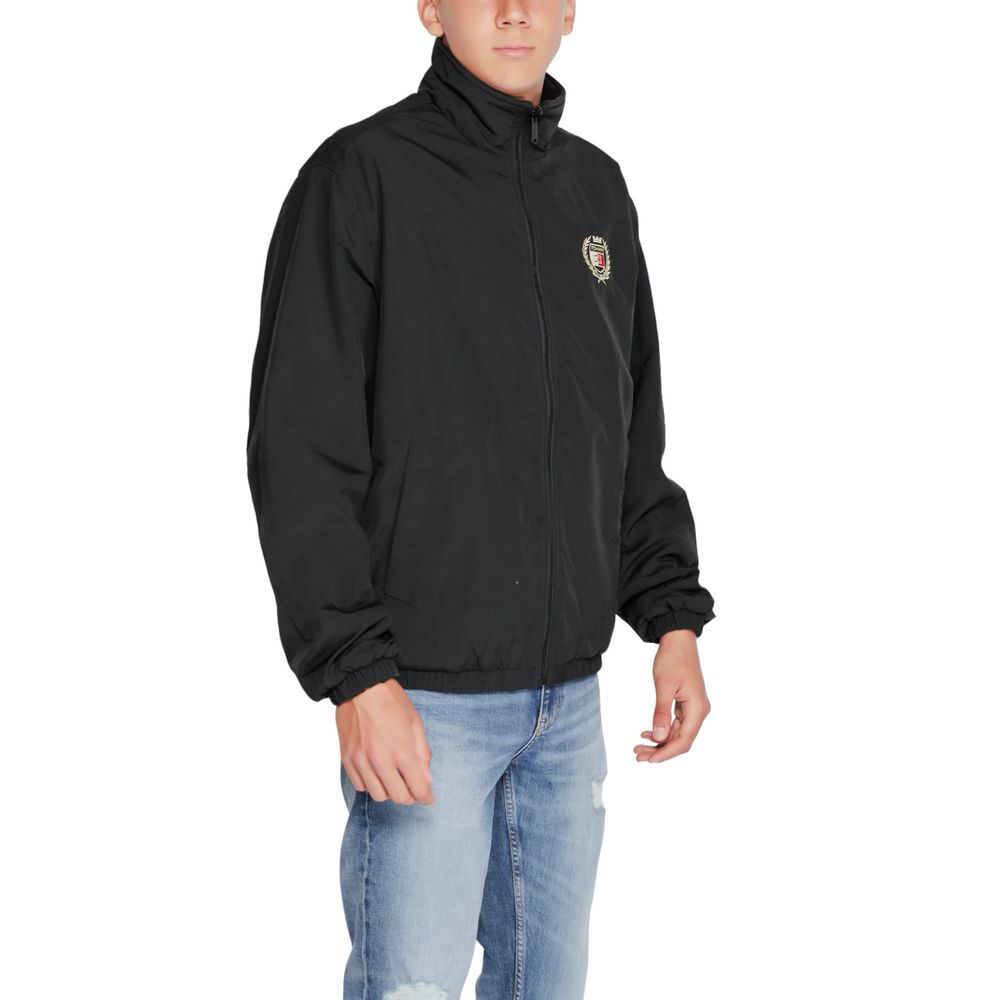 Trench Coat by Tommy Hilfiger Jeans for men in polyester black features an dramatic silhouette, perfectly showcasing the elegant high-collar neckline and sophisticated for a truly dramatic aesthetic.
