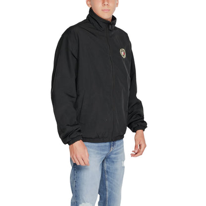 Trench Coat by Tommy Hilfiger Jeans for men in polyester black features an dramatic silhouette, perfectly showcasing the elegant high-collar neckline and sophisticated for a truly dramatic aesthetic.