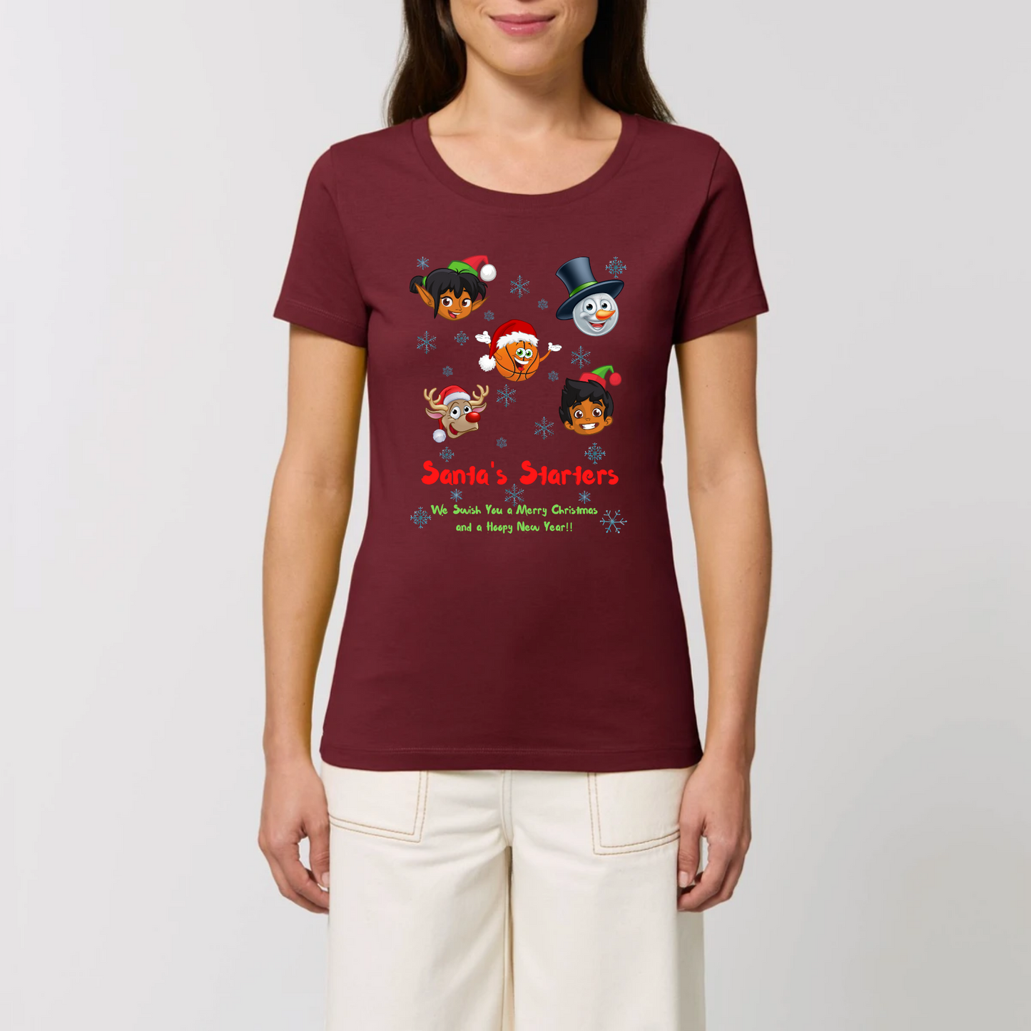 Model wearing a christmas t-shirt with a print design on front, The design has 5 cartoon character heads of 2 elves, a snowman, rundolf and a Basketball face with the heading Santa's starters and sub heading og We swish you a merry Christmas and a hoopy New Year. The t-shirt is Maroon