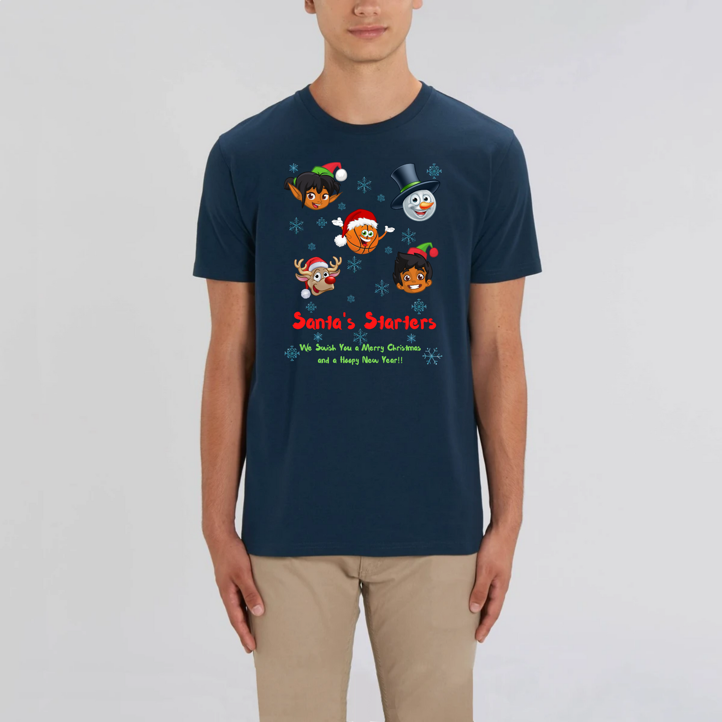 Model wearing a basketball themed Christmas t-shirt with a print design, The design features 5 cartoon character heads of 2 elves, a snowman, Rudolf and a basketball head with the heading Santa's Starters and sub heading We swish you a Merry Christmas and a Hoopy New Year. The t-shirt is Navy