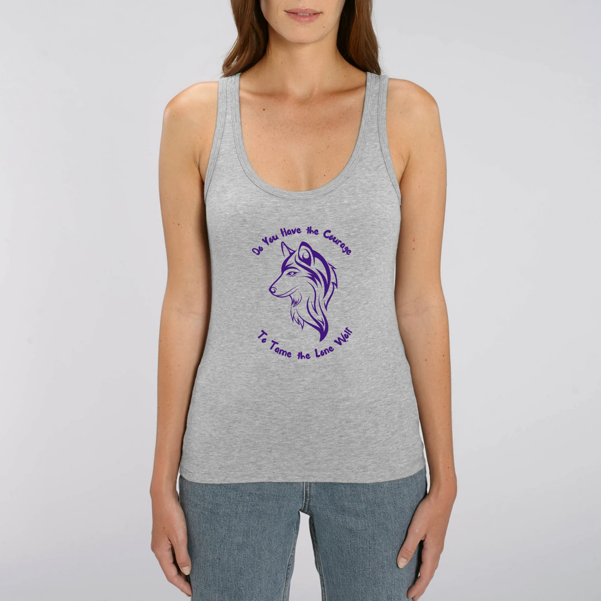 Model wearing a tank top with graphic design of a lone female wolf with wording Do you have the courage to tame the lone wolf. The tank top is grey